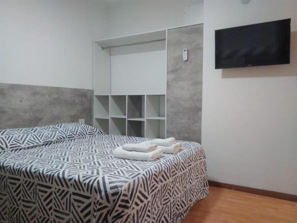 1 dormitorio con 1 cama con 2 toallas en Departamento Estudio 3 en Neuquén