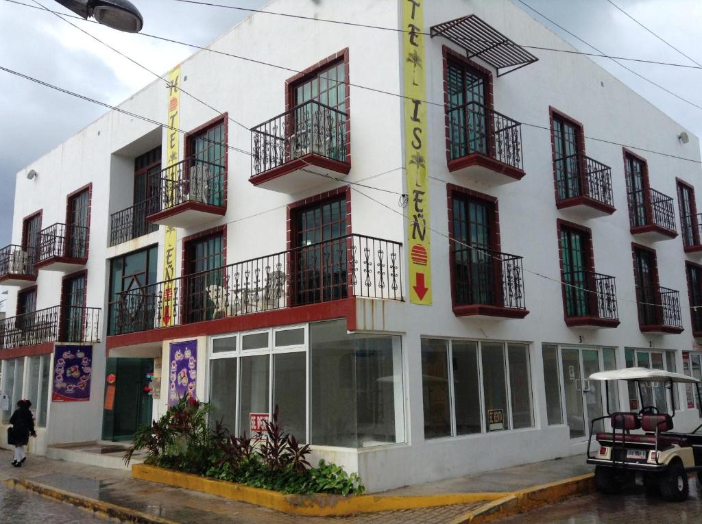 a white building with balconies on the side of it at Hotel Isleño in Isla Mujeres