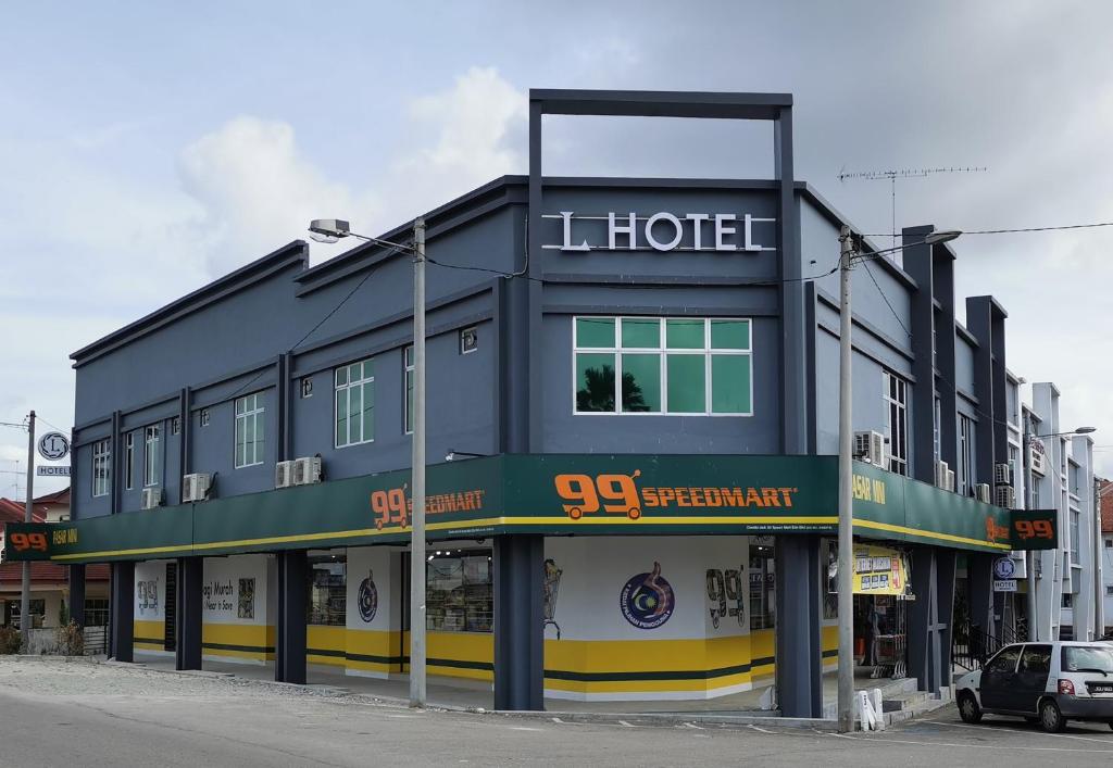 a blue building with a hotel on a street at L Hotel in Simpang Renggam