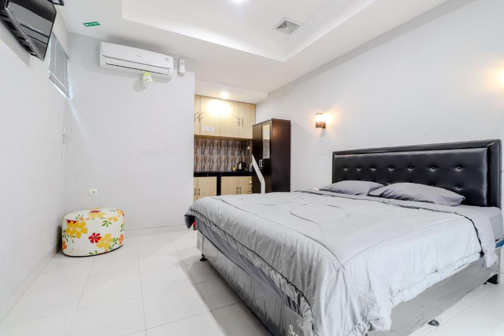 1 dormitorio con 1 cama grande en una habitación blanca en E Kamar Jogja en Yogyakarta