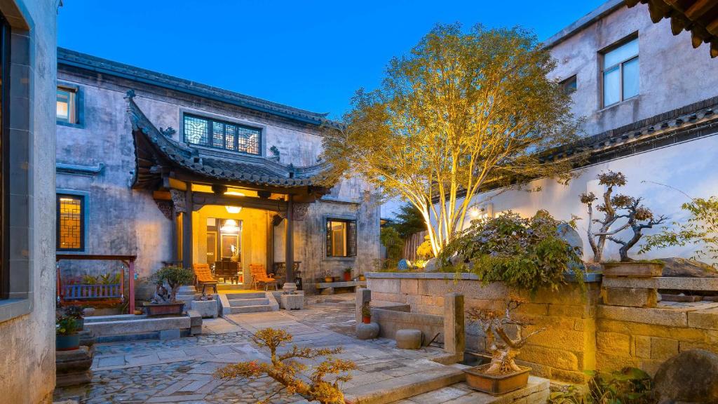 una casa antigua con un patio delante en Floral Guesthouse Huangshan Shuxiang Gongyuanli, en Tangkou