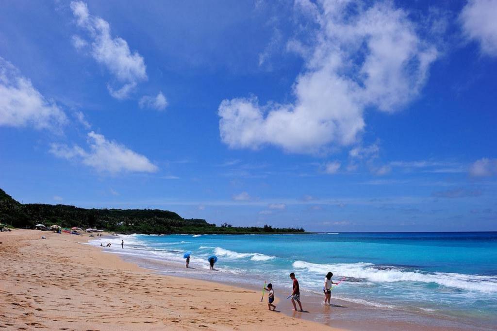 a group of people walking on the beach at Fei Li Jin Hotel in Kenting