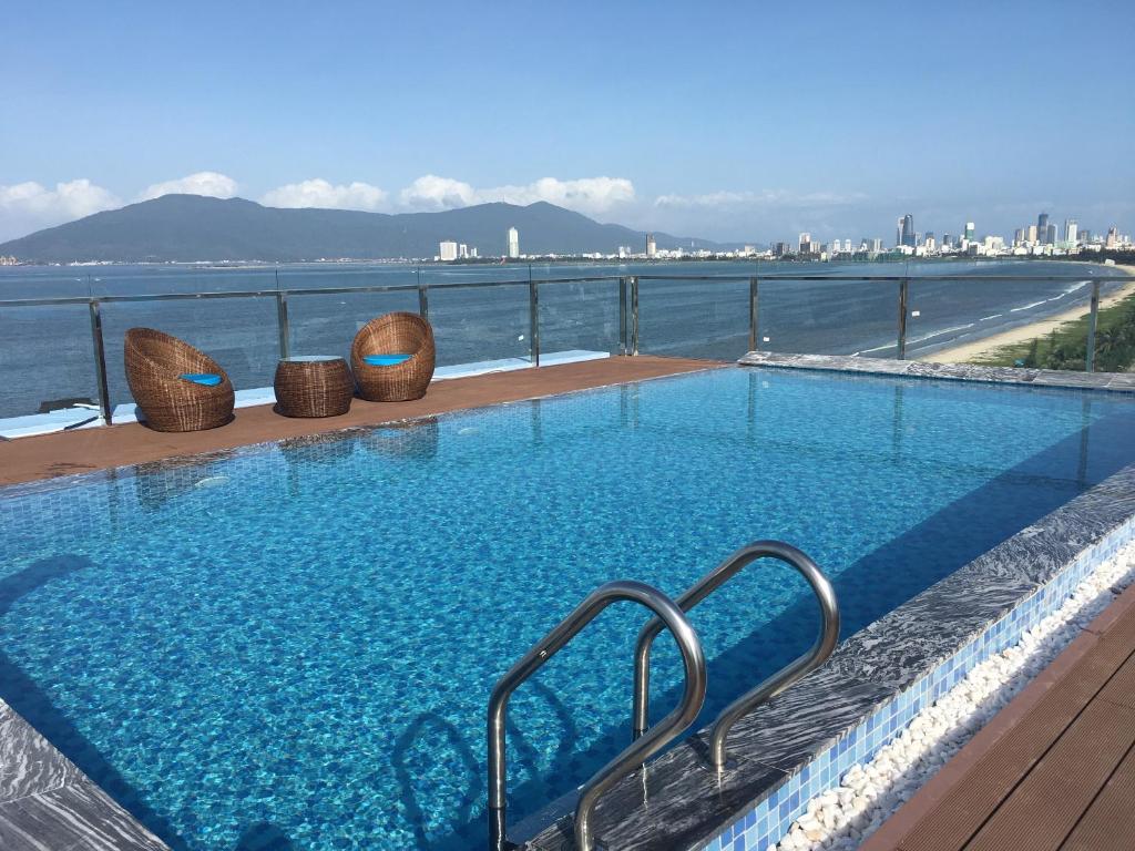 a swimming pool with a view of the water at Gold Boutique Hotel Danang in Da Nang