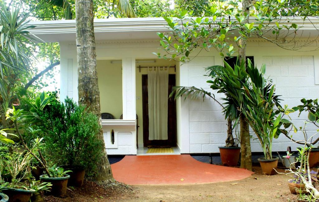 a white house with plants in front of it at Jickys Nest in Varkala
