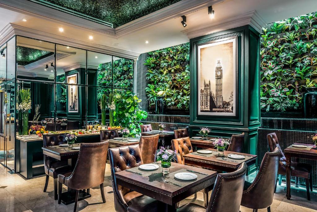 a restaurant with tables and chairs and plants on the walls at Silverland Jolie Hotel in Ho Chi Minh City