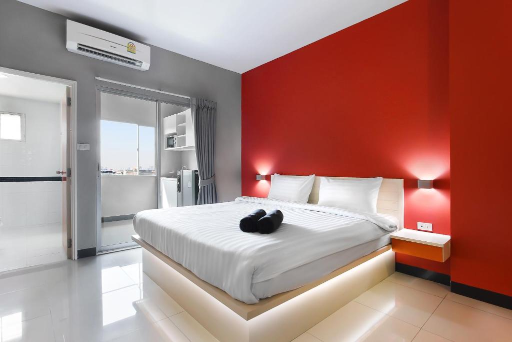 北欖的住宿－D Varee Xpress Fullroom 77 Srinakarin，一间卧室设有一张红色墙壁的大床