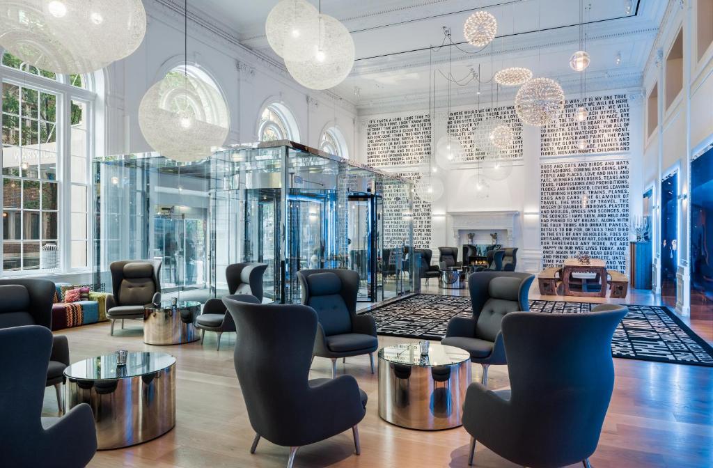 a salon with chairs and tables and chandeliers at The Warwick Hotel Rittenhouse Square Philadelphia in Philadelphia