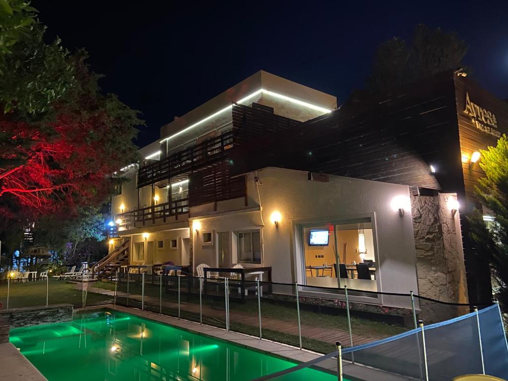 uma casa com piscina à noite em Ayres Village Apart em Pinamar