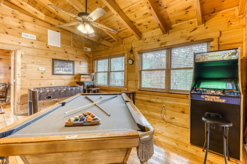 a game room with a pool table and a machine at Bear Tracks in Pigeon Forge
