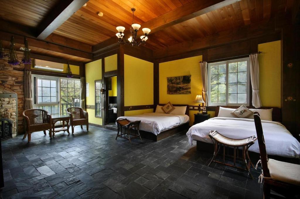 a bedroom with two beds and a table and chairs at Provence Rose Lodge in Ren'ai