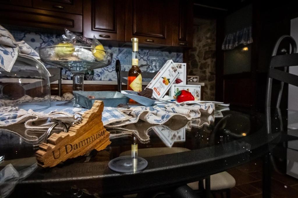 a kitchen counter with a table with food and a bottle of wine at U Dammusu in Modica