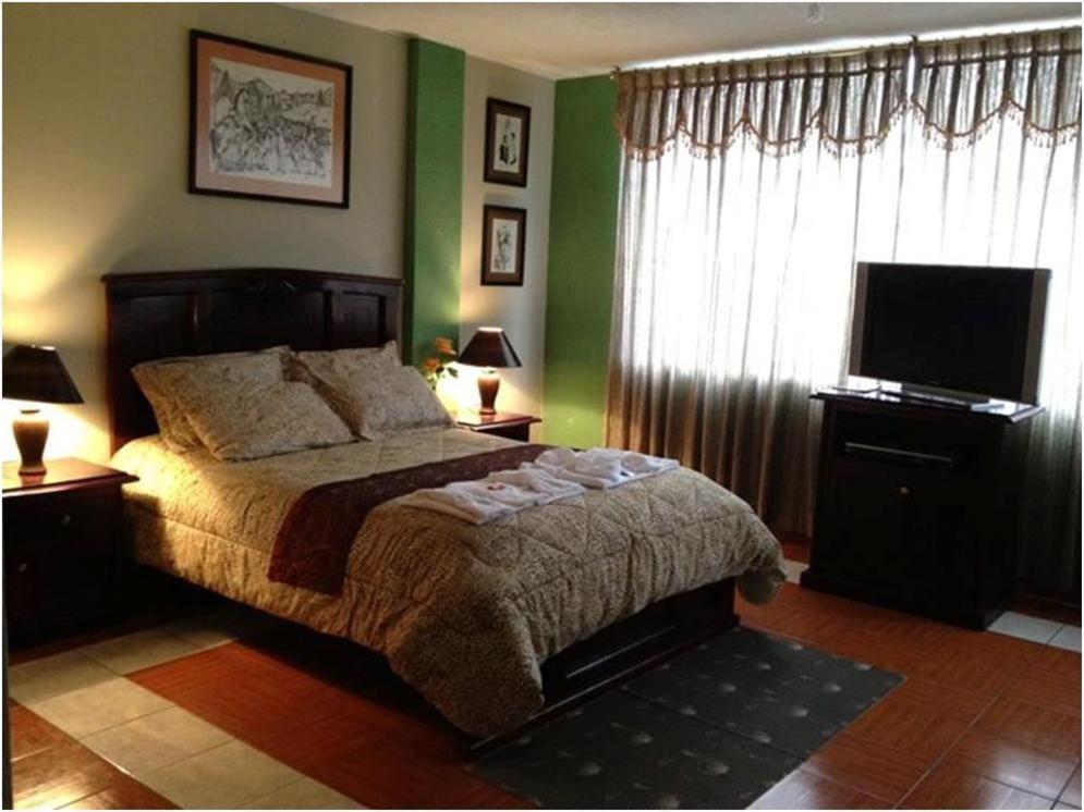 コタカチにあるHostal Jora Continentalのベッドルーム(ベッド1台、薄型テレビ付)