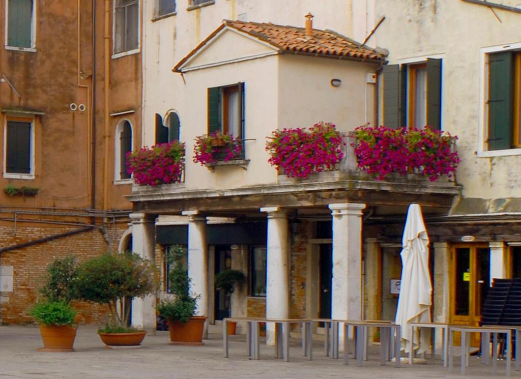 a building with flower boxes and an umbrella at Locanda del Ghetto in Venice