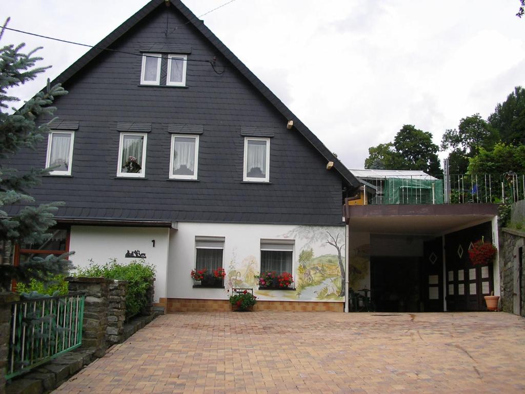 a black and white house with a garage at Ferienwohnung Neubert in Breitenbrunn