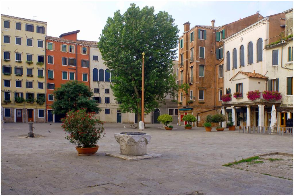 a city square with buildings and a bench and trees at Locanda del Ghetto in Venice