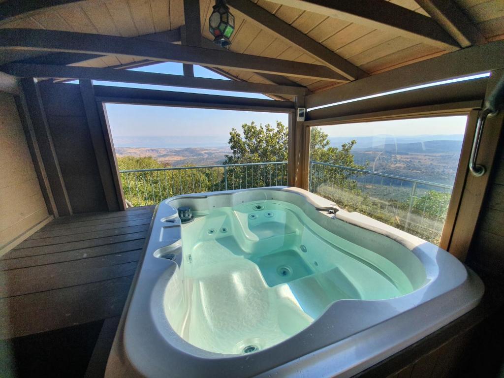 a bath tub in a room with a view at Switzerland In Amirim in Amirim