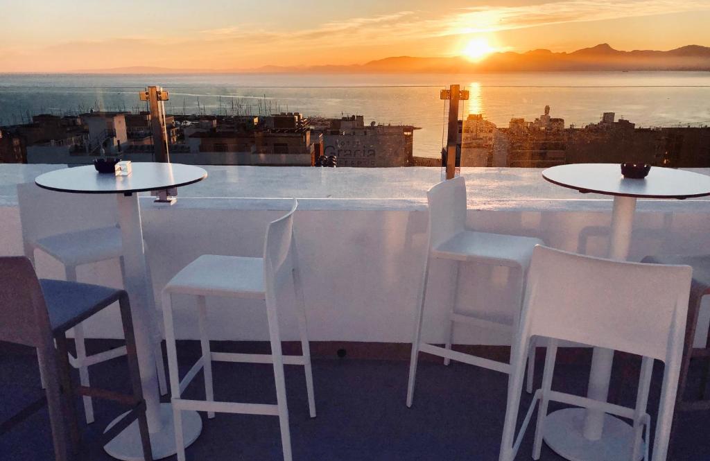 a bar with white chairs and a view of the sunset at BLUESEA Arenal Tower Adults Only in El Arenal