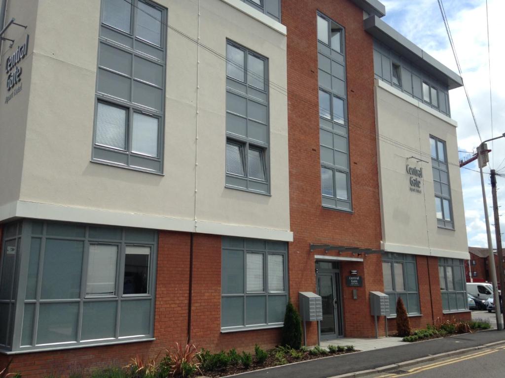 a brick building with windows on a street at House of Fisher - Central Gate in Newbury