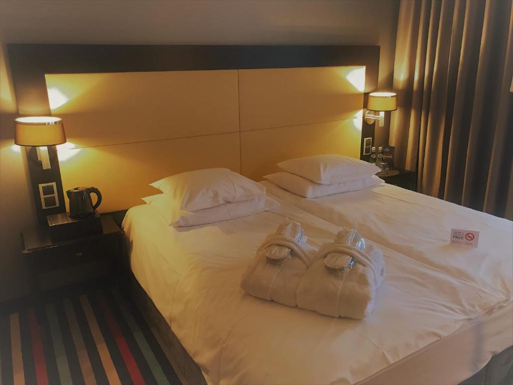 a hotel room with a bed with two bags on it at Silver Hotel & Gokart Center in Szczecin