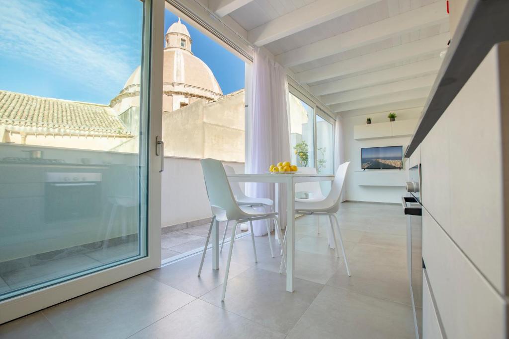 a room with a table and chairs and a window at Le Cupole Suites & Apartments in Trapani