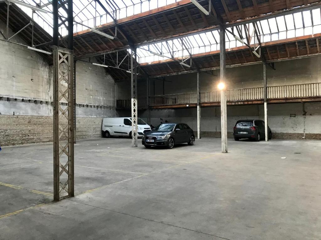 a parking garage with three cars parked in it at Grand Hôtel d&#39;Orléans in Toulouse
