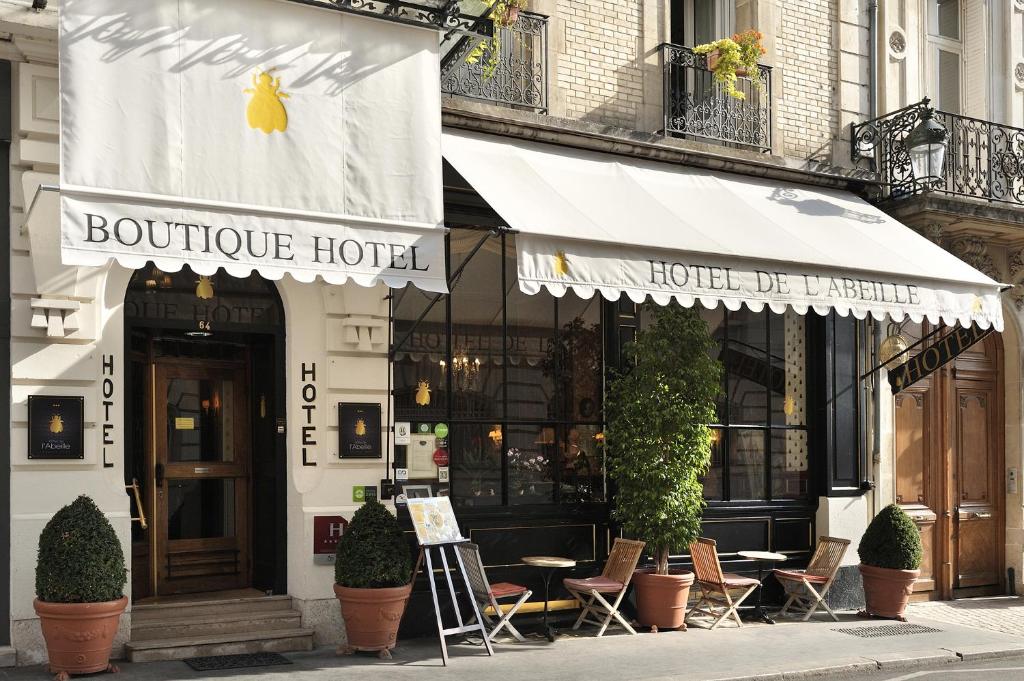 een boetiekhotel met stoelen en tafels in een straat bij Hôtel de l'Abeille in Orléans