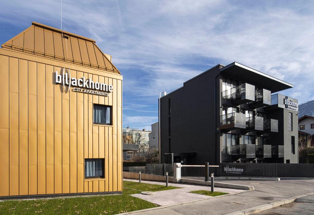 a yellow building next to a black building at Blackhome Innsbruck City East I contactless check-in in Innsbruck