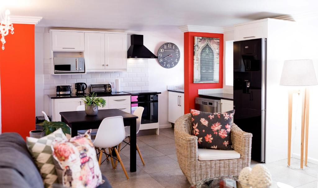 eine Küche und ein Wohnzimmer mit Tisch und Stühlen in der Unterkunft 1926 Self Catering in Piketberg