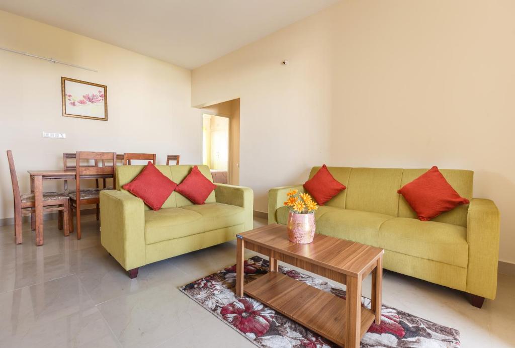 Sala de estar con 2 sofás y mesa en Misty Meridian Serviced Apartments, en Bangalore