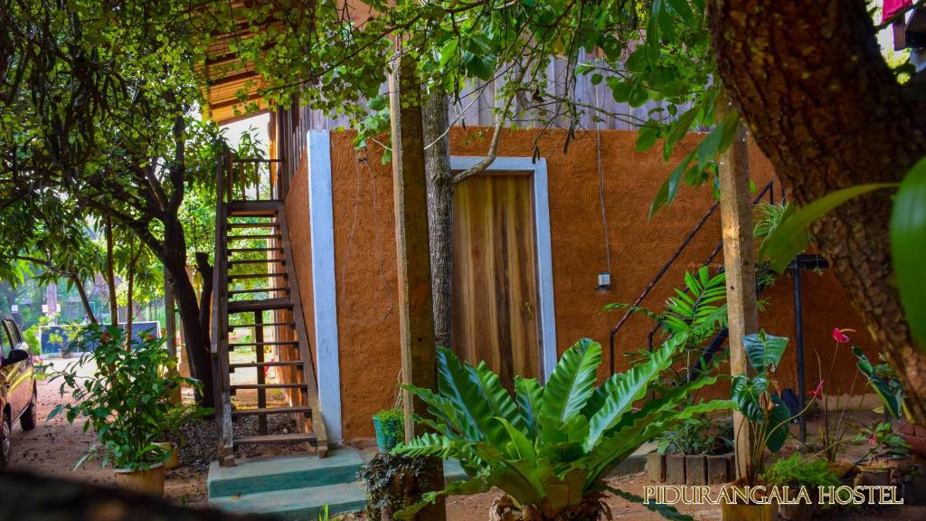a house with a staircase leading to a door at Pidurangala Hostel in Sigiriya