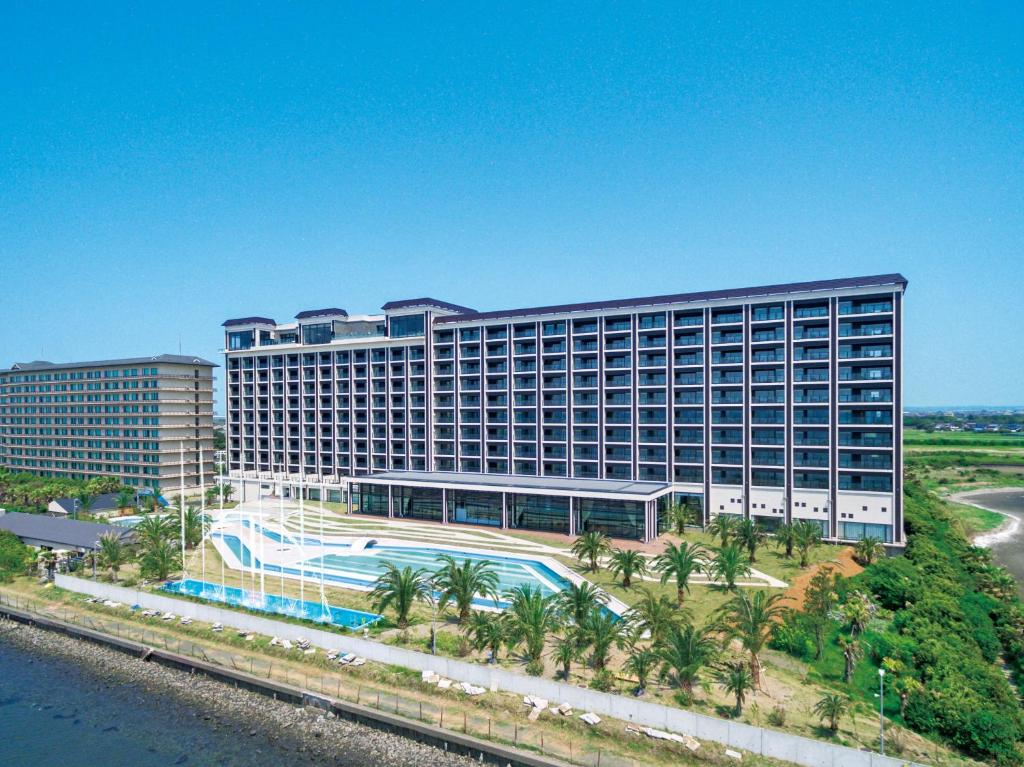 a large building with a swimming pool in front of it at Ryugujo Spa Hotel Mikazuki Fujimitei in Kisarazu