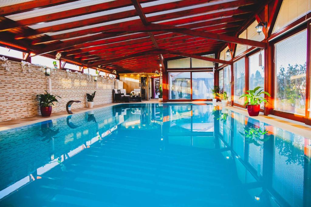 a swimming pool with blue water in a building at Barackos Wellness Villa Fót in Fót