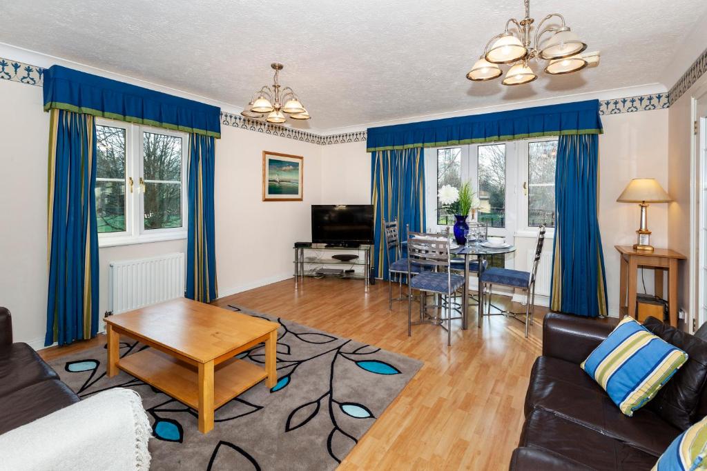 uma sala de estar com cortinas azuis e um sofá em Churchill Way Suite em Basingstoke