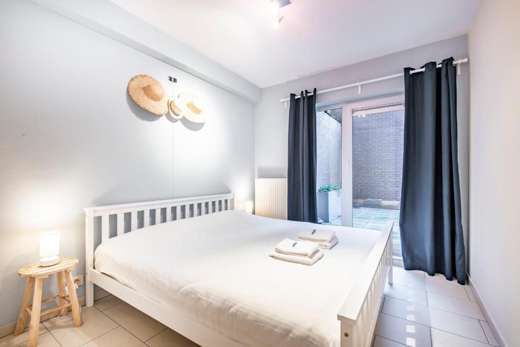 una camera con un letto bianco e una finestra di Centrally located apartment in Knokke a Knokke-Heist