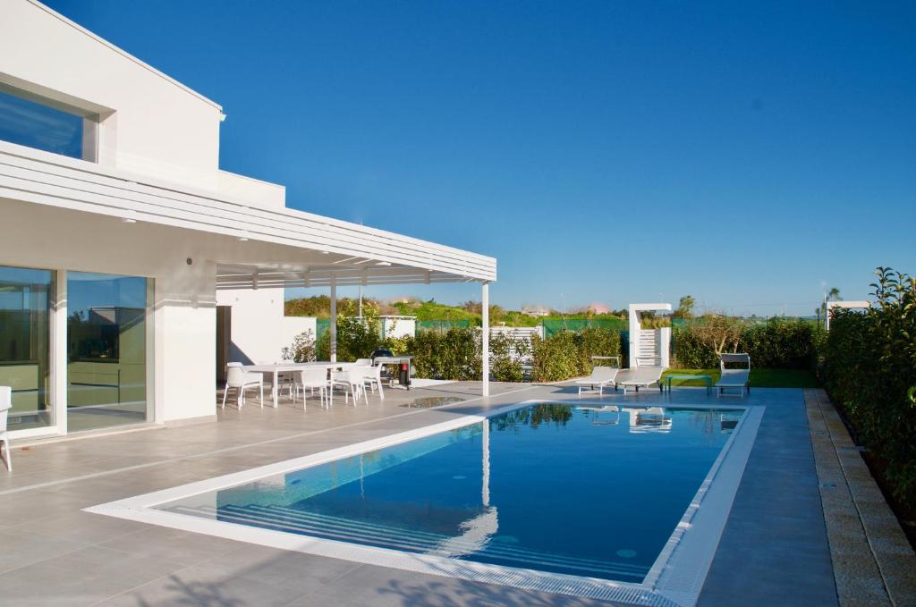 une piscine dans l'arrière-cour d'une maison dans l'établissement villa MAMA Marina di ragusa, à Marina di Ragusa