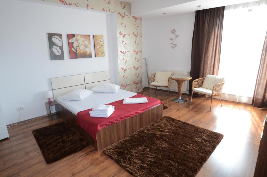 a bedroom with a large bed with a red blanket at Mosilor Apartments in Bucharest