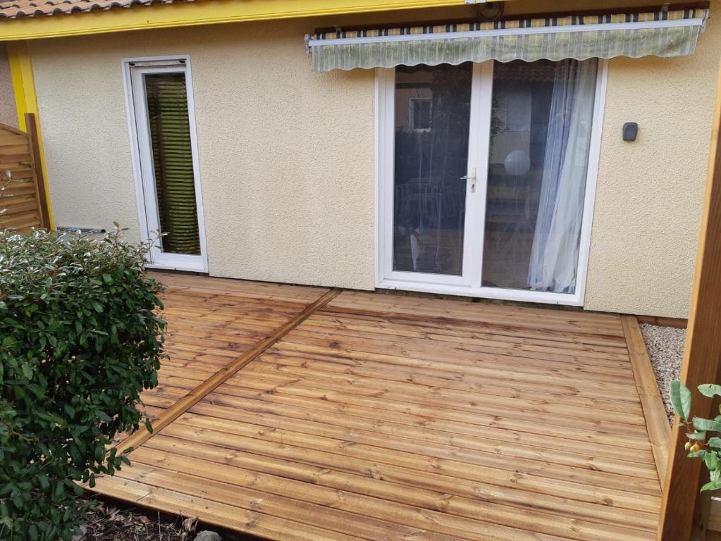 a wooden deck in front of a house at Résidence VILLAS DU LAC in Soustons