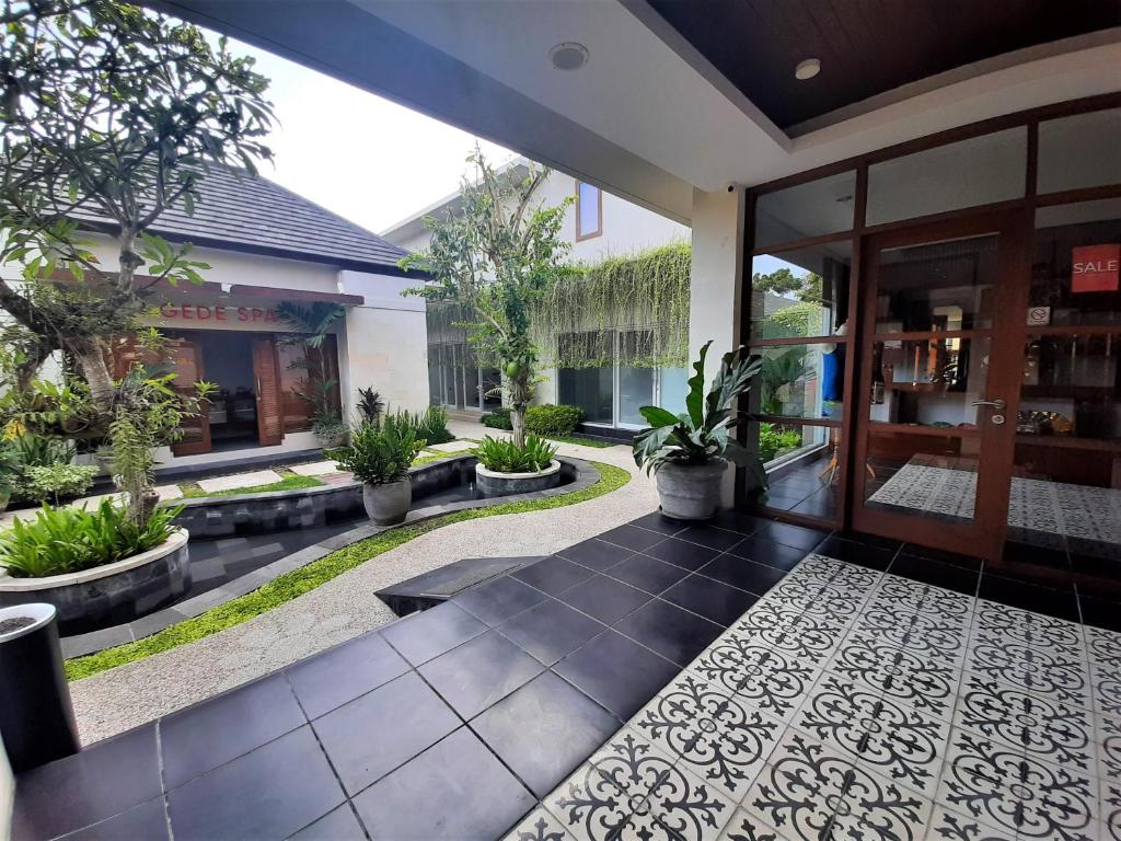 an entrance to a house with a courtyard with potted plants at Gaing Mas Jimbaran Villas by Gaing Mas Group in Jimbaran