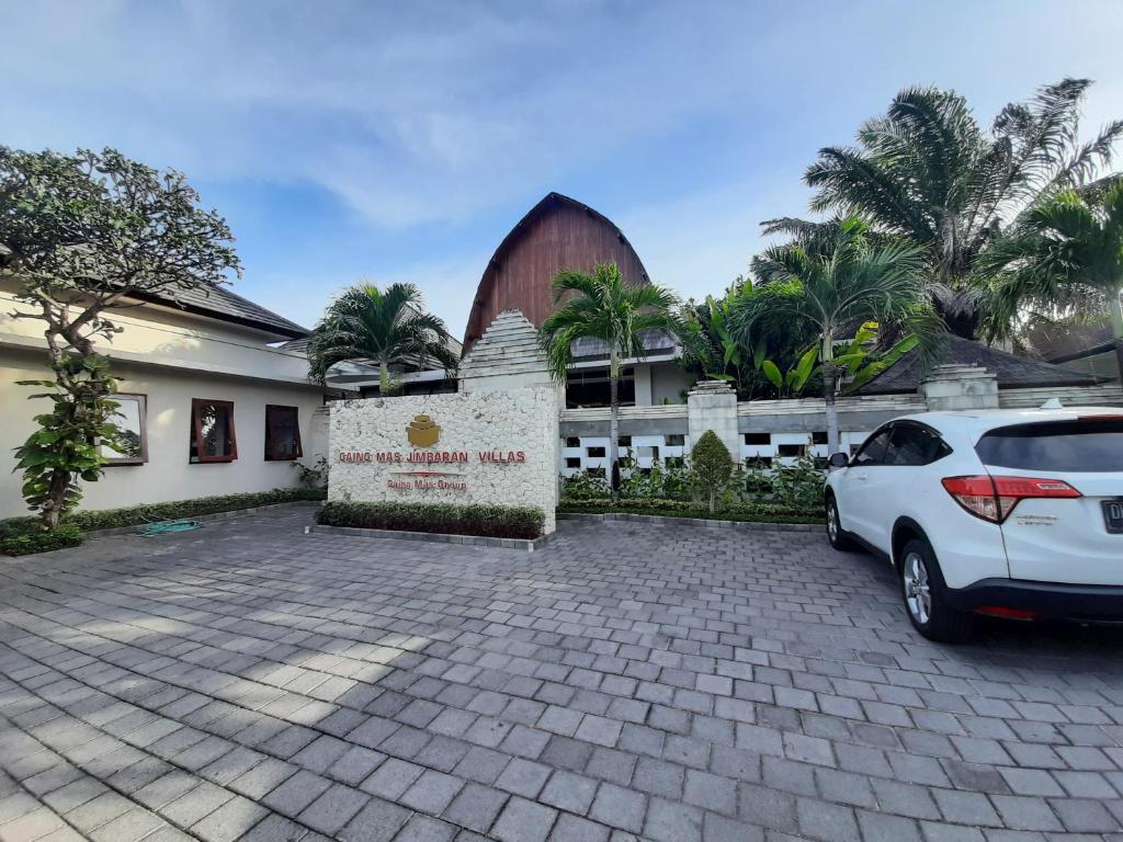 a white car parked in front of a building at Gaing Mas Jimbaran Villas by Gaing Mas Group in Jimbaran