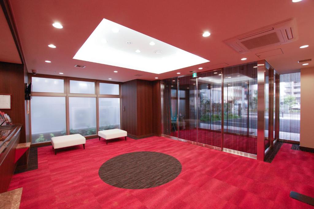 相模原市にあるアイホテル橋本の赤いカーペットと窓が備わる広い客室です。