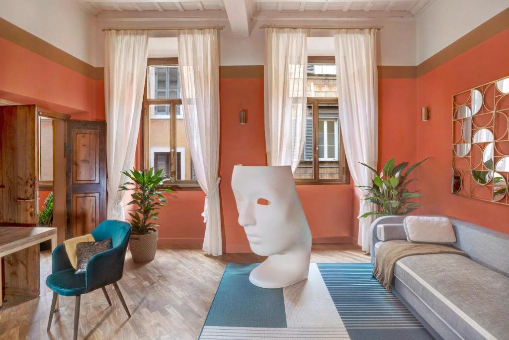 - un salon avec des murs orange et un canapé dans l'établissement Luxury Trevi House, à Rome