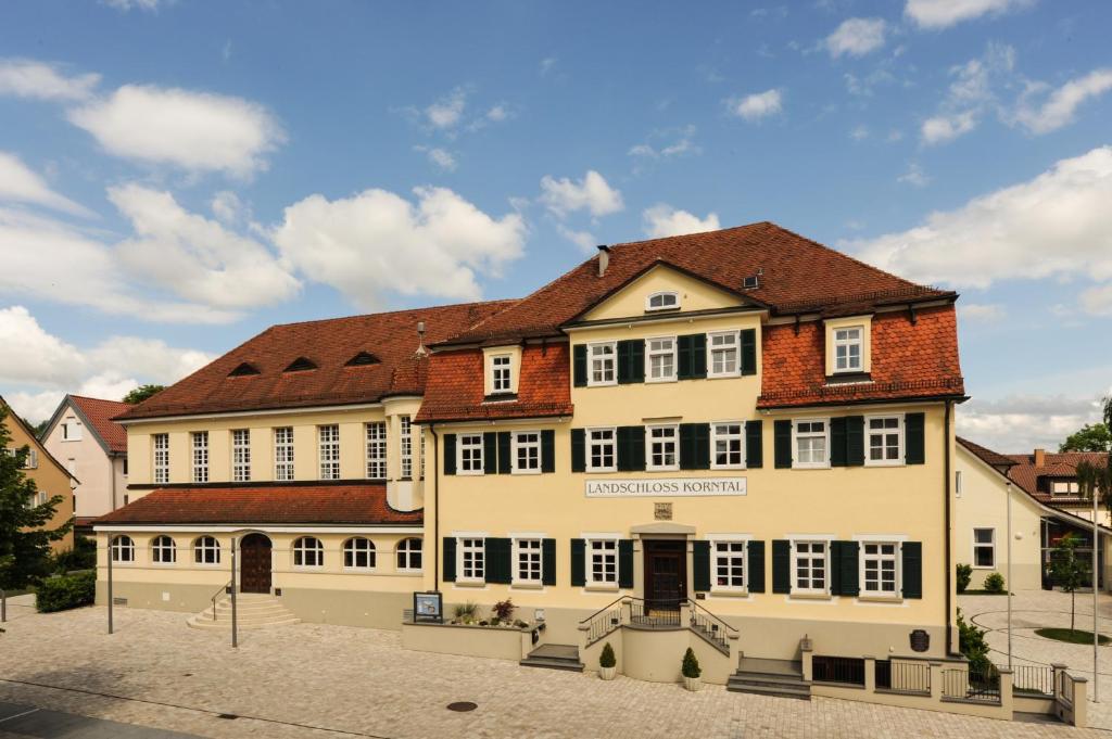ein großes weißes Gebäude mit braunem Dach in der Unterkunft Landschloss Korntal in Korntal-Münchingen