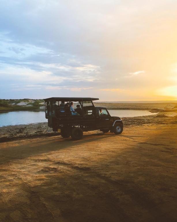 a jeep driving down a dirt road with people in it at Leopard Nest - Glamping in Yala in Yala