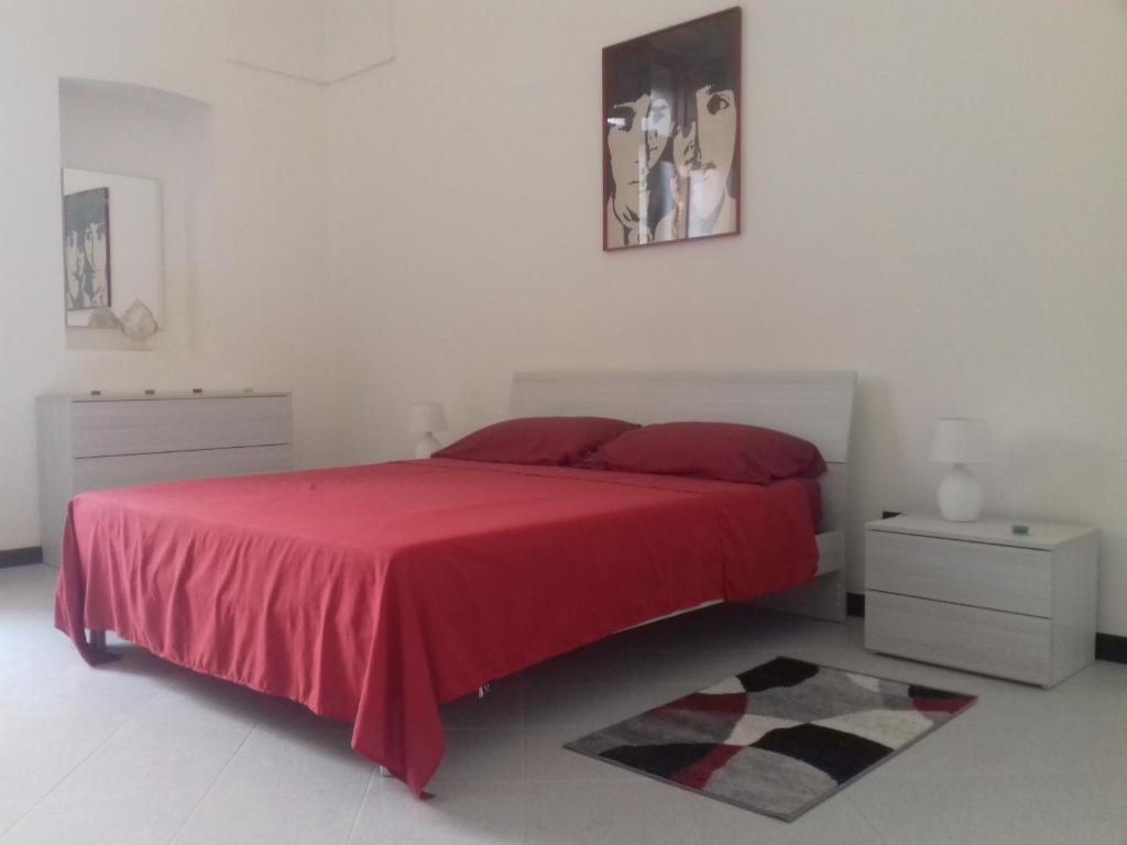 ein Schlafzimmer mit einem roten Bett mit einer roten Decke in der Unterkunft HAPPY HOUSE Salento Apartment in Brindisi