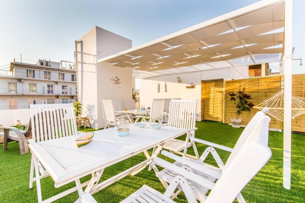 patio z białym stołem i krzesłami na trawie w obiekcie Neoclassical apartment with 2 bedrooms in Piraeus w Pireusie