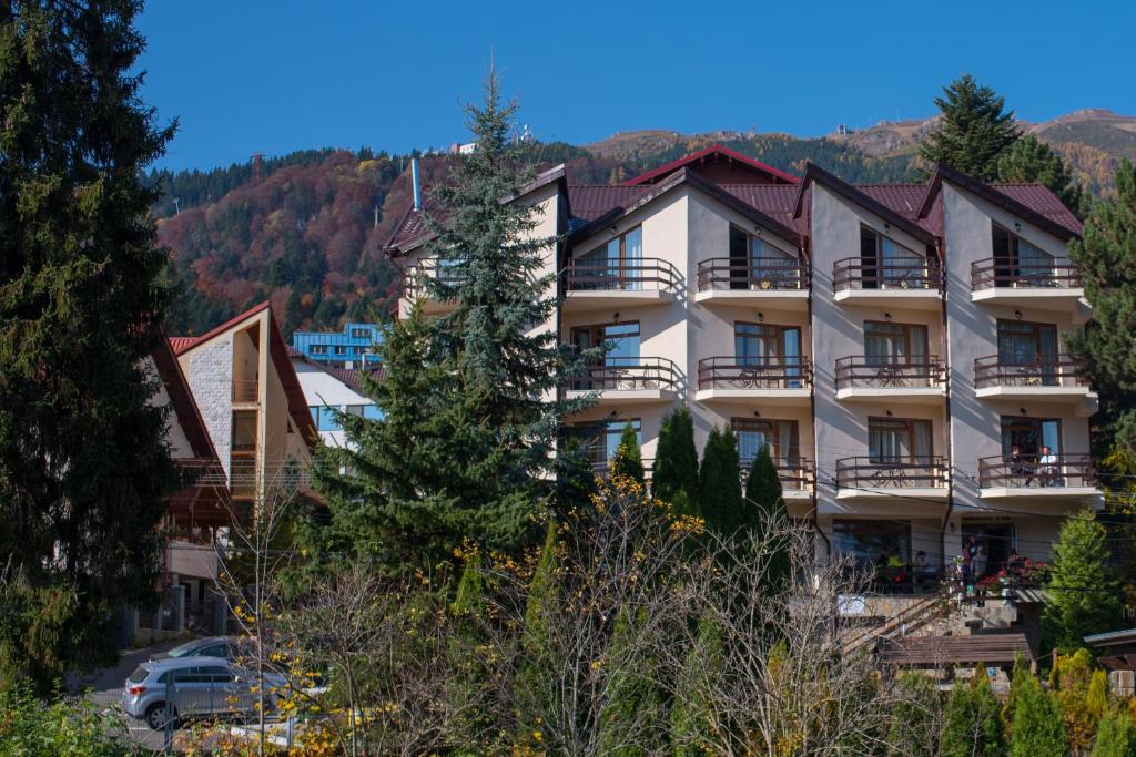 a hotel in the mountains with a car parked in front at Hotel Marea Neagra in Sinaia