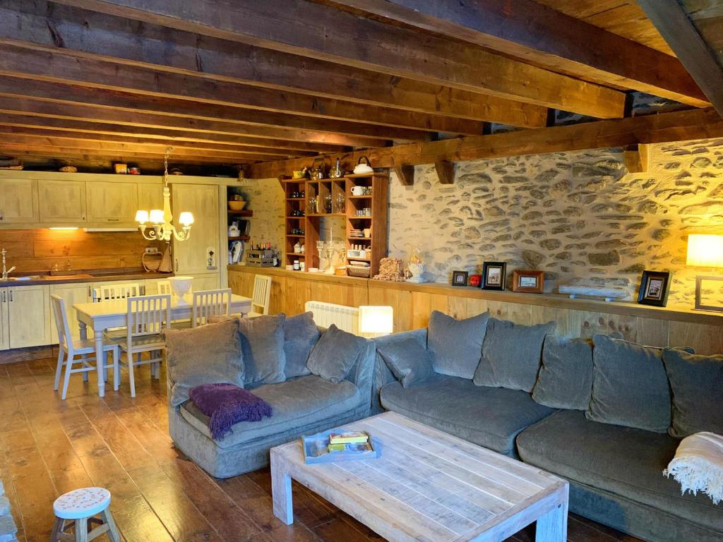 uma sala de estar com um sofá e uma mesa em Casa rústica actualizada en Oseja em Osséja