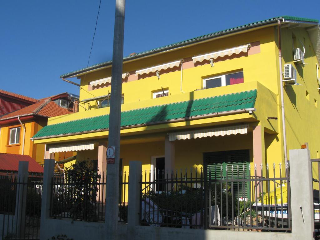 a yellow house with a fence in front of it at casa andrei m in Eforie Sud
