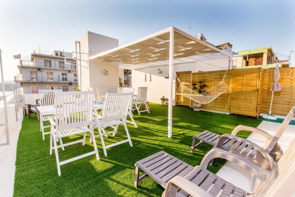 a patio with chairs and a hammock on a roof at Neoclassical flat with 2 bedrooms in Piraeus in Piraeus