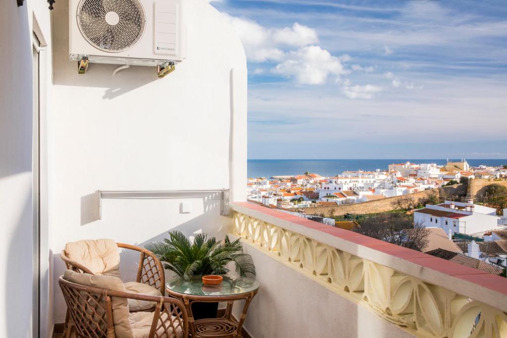 a balcony with a table and a view of the ocean at Apartamento Santo Amaro in Lagos